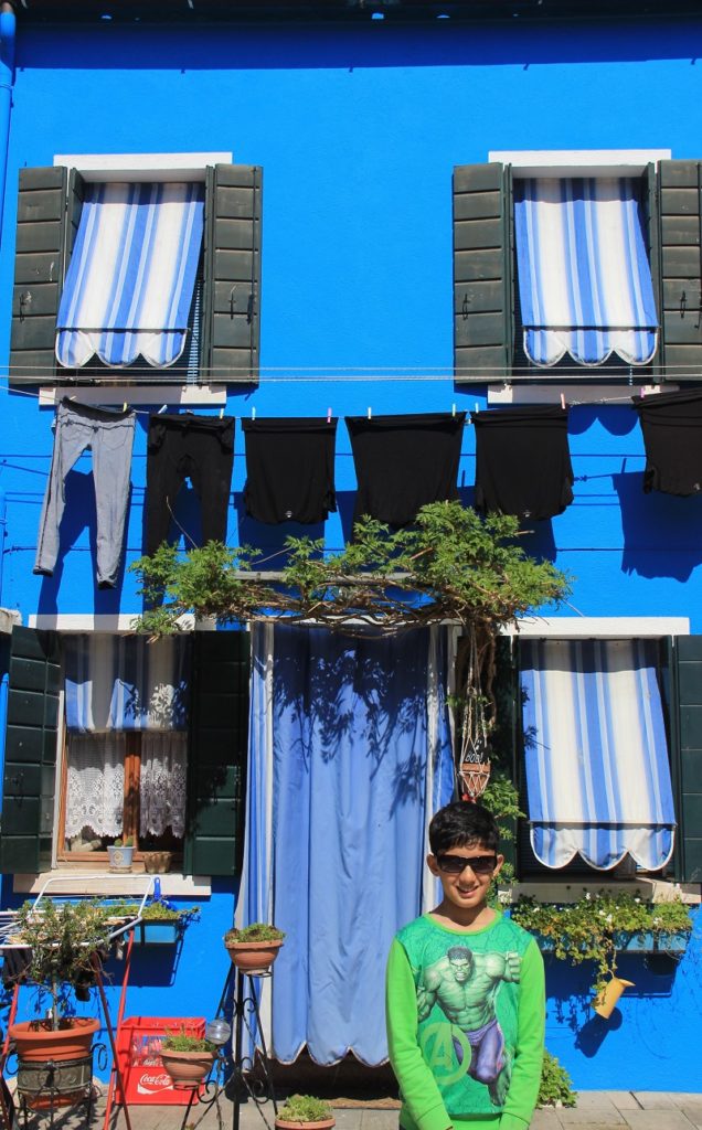 In front of a colorful house in Burano on a day trip from Venice
